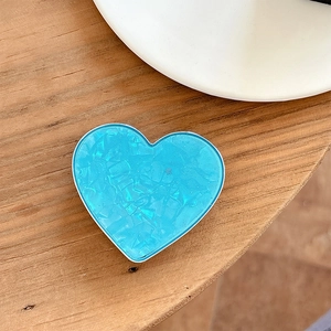 Close-up of heart-shaped blue glitter phone socket holder on a wooden surface