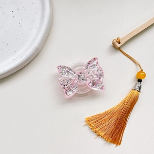 Detail of pink glitter bow phone grip with translucent resin and retractable base