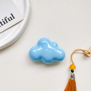 Macro shot of sky blue cloud-shaped phone grip with high gloss finish on leather texture