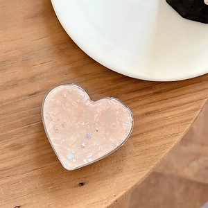Close-up of heart-shaped phone socket with pink shell texture and star sequins