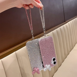 Detail of pink and silver rhinestone phone case with glitter strap and butterfly charm