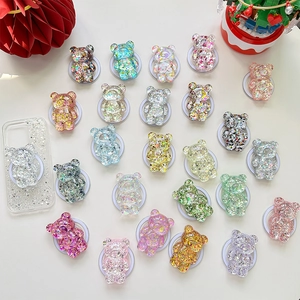 Flat lay of colorful glitter bear phone grips with a transparent sparkling case