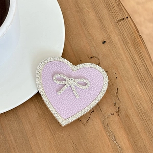 Macro shot of a lavender leather heart phone stand with rhinestone trim and bow detail