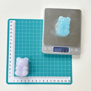 Macro view of jelly bear phone grip showing size and weight on digital scale