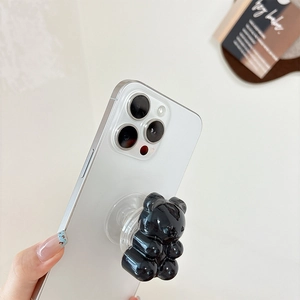 Detail of 3D black jelly bear phone grip with high-gloss mirror finish on smartphone