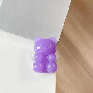 Detail of purple gummy bear phone grip stand with translucent resin on a white desk