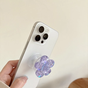 Close-up of a purple glitter flower grip tok attached to a white smartphone