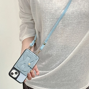 Detail of light blue leather phone case with bow card holder and detachable crossbody strap