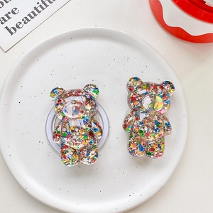 Macro detail of clear resin bear phone grips with colorful glitter and star sequins