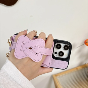 Detail of light purple leather phone case with V-shaped hand strap and gold hardware