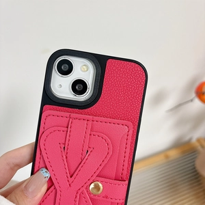 Close-up of rose pink lychee leather iPhone case with card slot and metal button detail