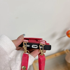 Detail view of iPhone case charging port with rose red leather card holder and lanyard
