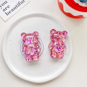 Detail of pink glitter bear phone grip stand made of transparent resin material