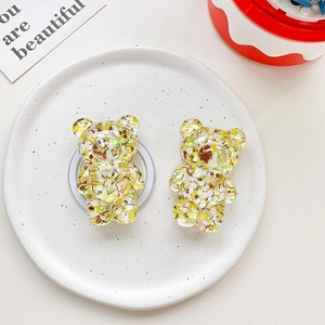 Close-up of yellow glitter bear phone socket stands with resin sequins on a white plate