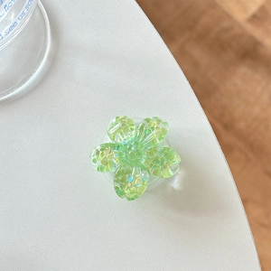 Macro detail of a 3D translucent green flower phone grip with glitter heart sequins