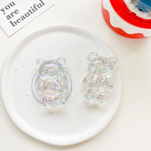 Detail of cute 3D glitter bear phone grip holders with colorful sequins in a ceramic tray