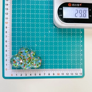 Detailed view of cloud phone stand with colorful sequins showing 6.5cm length and weight