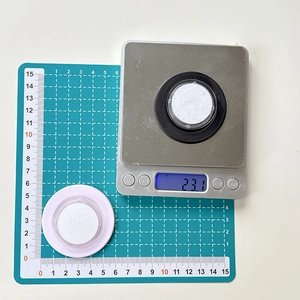 Macro detail of round magnetic phone stand components weighing 23.1g on digital scale