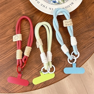 Three colorful braided cotton phone wrist straps in red, green and blue with leather tags