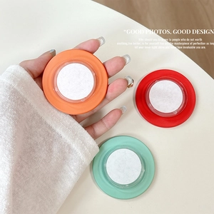 Close-up of minimalist retractable magnetic phone sockets in orange, red, and mint green