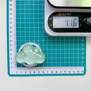 Macro view of a light green glittery cloud phone grip on a scale showing 41.6g weight