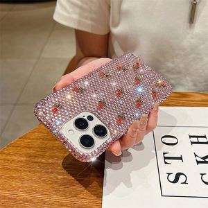 Detail of luxury iPhone case with pink rhinestones and 3D cherry accents in hand