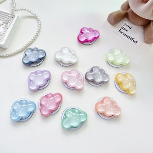 Glittery cloud-shaped phone socket grips in colorful macaron colors on flat surface