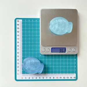Macro detail of matte blue taiyaki fish phone socket showing 36.2g weight and 5cm size