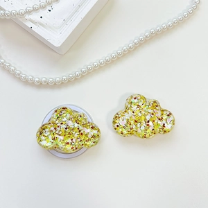 Detailed view of cloud-shaped phone grip with glitter resin and pearl accessories
