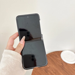 Handheld view of a black textured leather folding phone case for Galaxy Z Flip series