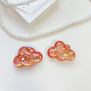Close-up of cloud-shaped glitter resin phone grip with pink and gold sequins details