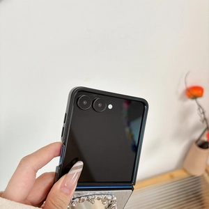 Détail d'étui en cuir pour téléphone pliable avec miroir cœur diamant et chaîne