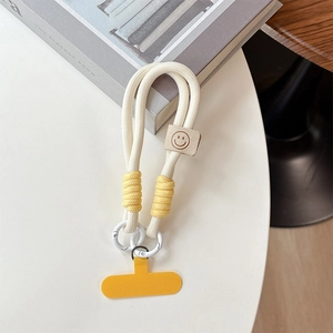 Detail of cream braided phone lanyard with yellow accents and a leather smiley face patch