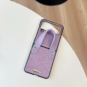 Detail of light purple leather texture phone case with hand strap and metal logo