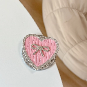 Detail view of pink leather heart phone stand with rhinestone bow and sparkling border