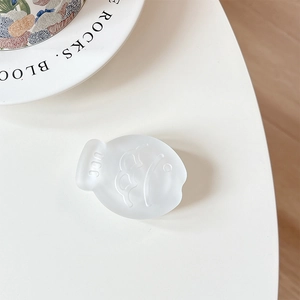 Detail of matte white cartoon fish phone grip stand on a minimalist white table