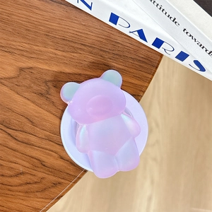 Primo piano di un supporto per telefono a forma di orso iridescente laser su legno
