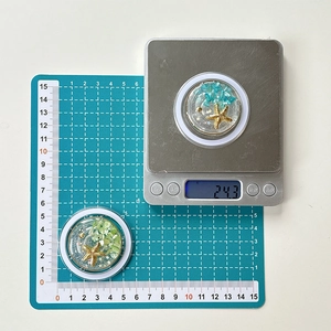 Detail view of ocean-themed phone grip featuring natural stones and a golden starfish