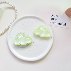 Detail of glitter cloud phone grip and matching accessory on white ceramic tray