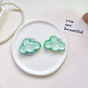 Detailed view of cloud-shaped glitter phone socket on a white dish with pearls
