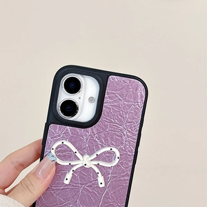 Detail view of purple crinkled leather phone case with a white polka dot bow decoration