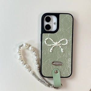 Detail of light green leather iPhone case with polka dot bow and pearl wrist strap