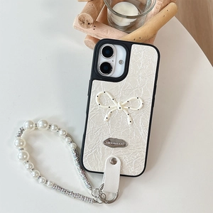 Detail of cream leather iPhone case with polka dot bow and pearl rhinestone strap