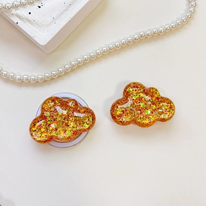 Detail of cloud-shaped phone socket with colorful sequins in transparent resin texture