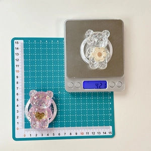 Détails du support téléphone ours à fleurs avec dimensions et poids sur une balance