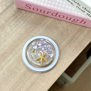 Detailed macro view of marine themed phone grip with starfish and purple stones
