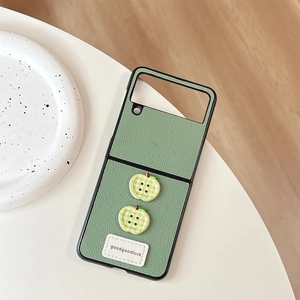 Detail of green leather Z Flip phone case with apple buttons and goodgoodluck label