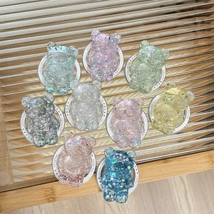 Sparkly bear-shaped resin magnetic phone grips in assorted colors on glass surface