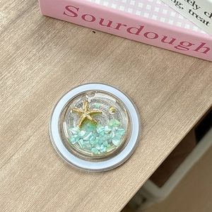 Detailed top view of a resin phone grip featuring starfish, shells, and turquoise stones