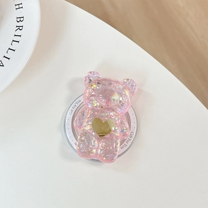 Détail d'un support de téléphone ours rose à paillettes avec un petit cœur doré